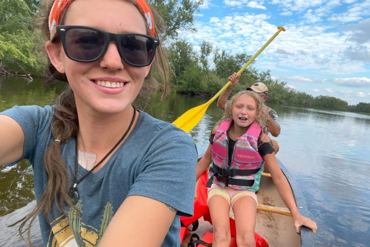 Marie Louise Poulsen wearing sunglasses and smiling next to a body of water