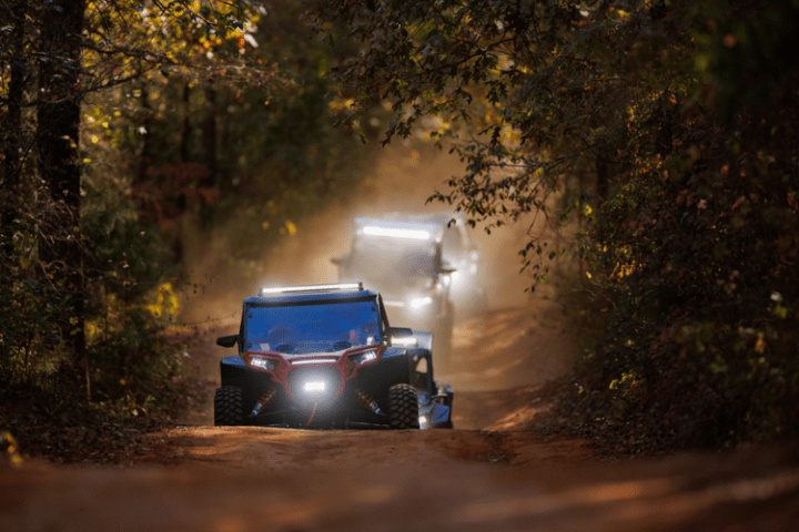 three UTVs driving down a dirt trail