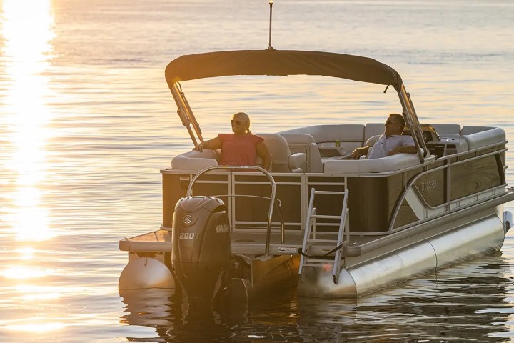 a couple relaxing on a pontoon in a lake