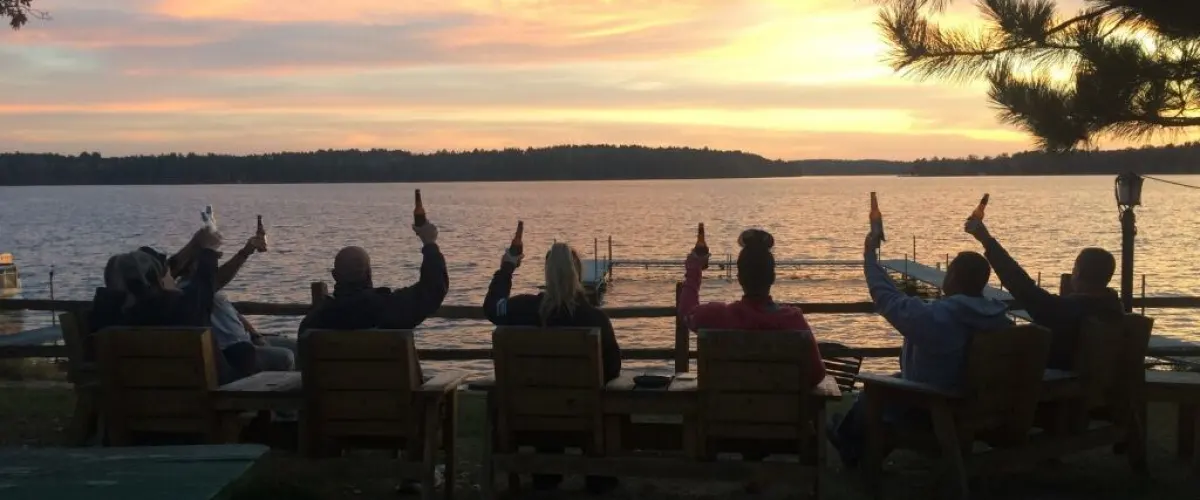 a group of people sitting on a bench next to a body of water