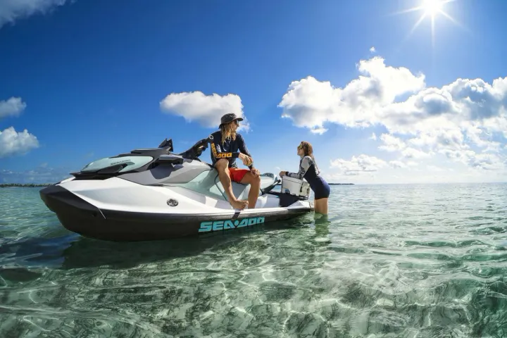 a man riding on the back of a boat in a body of water
