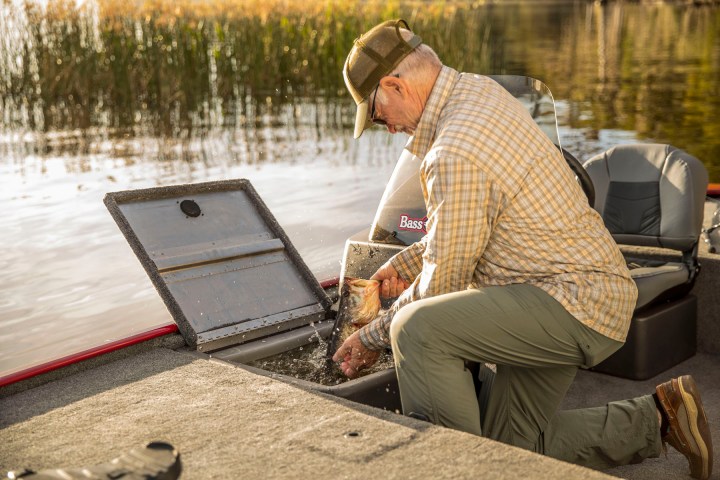 a man sitting on a bench looking at a laptop