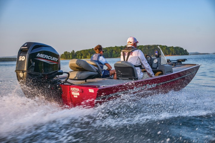 a group of people riding on the back of a boat in the water