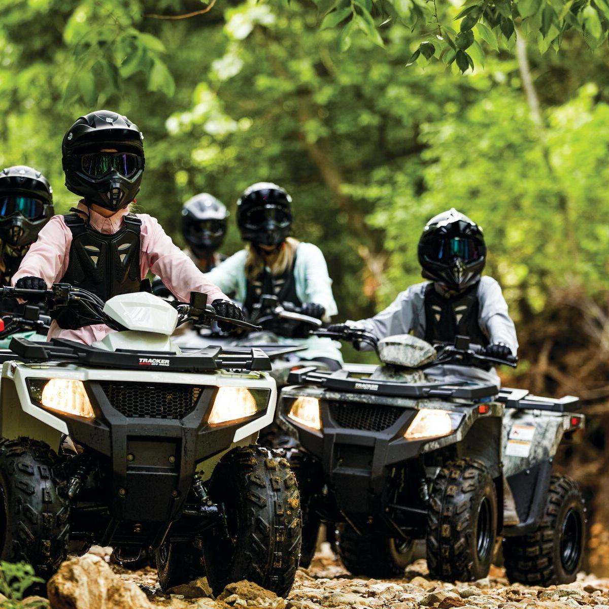 a man riding a motorcycle down a dirt road