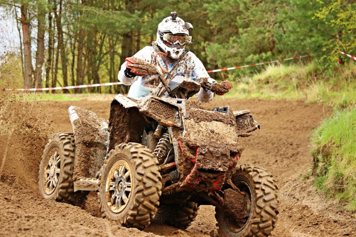 a man riding a bike down a dirt road