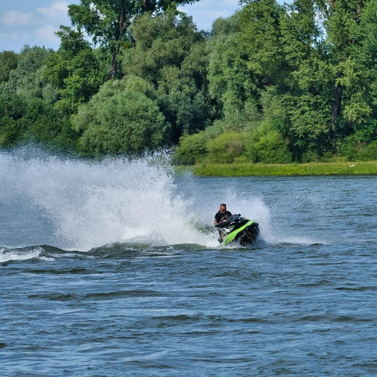 a man riding on the back of a boat in a body of water