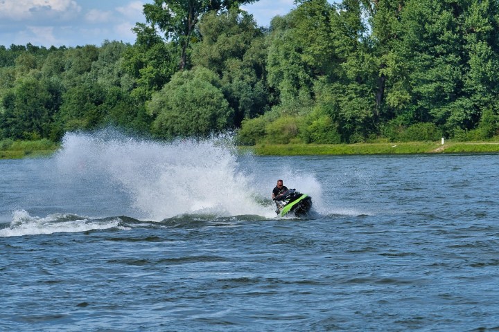 a man riding on the back of a boat in a body of water