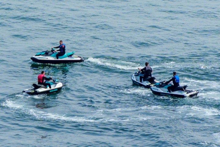 a group of people riding on the back of a boat in the water