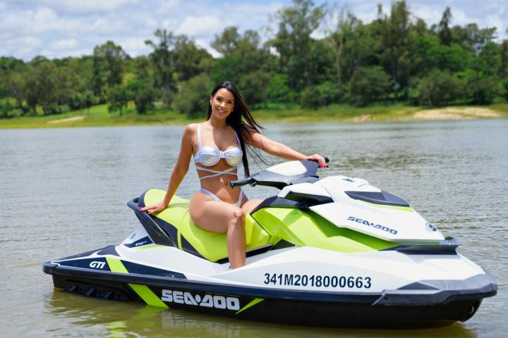 a person riding on the back of a boat on a body of water