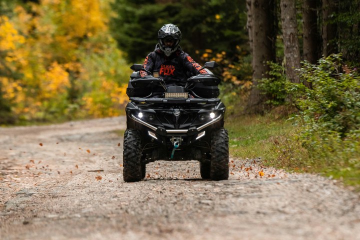 a man riding a motorcycle down a dirt road